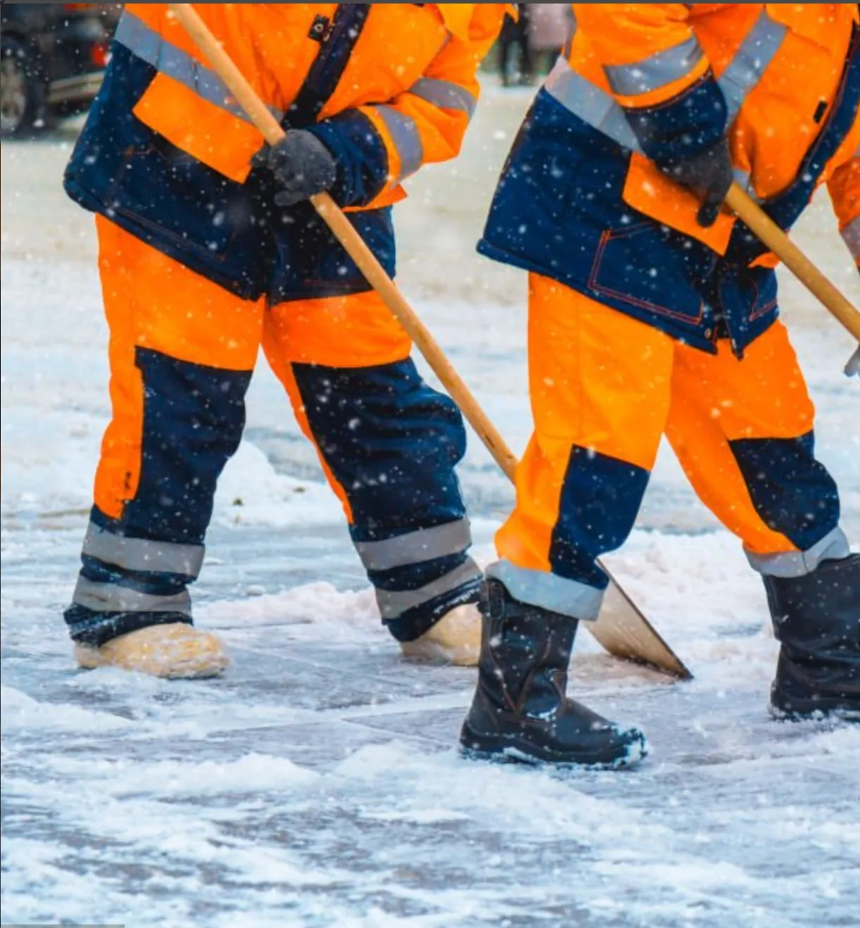 Snow removal workers clearing icy ground